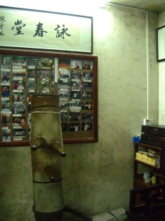 Old wooden dummy, with old pictures on the wall